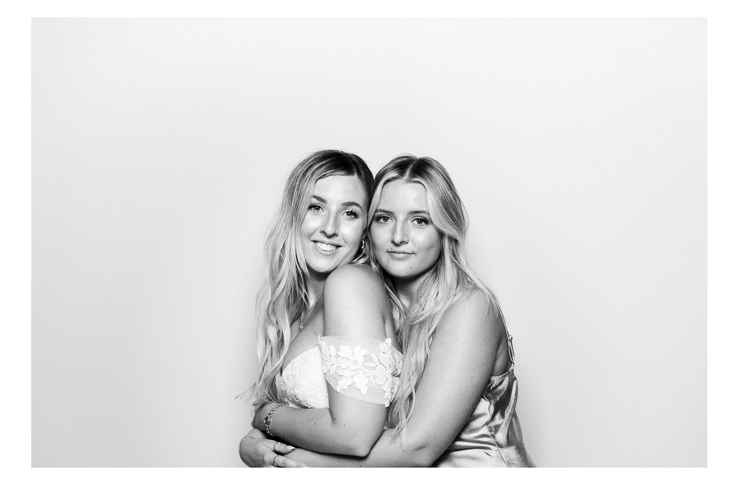 Sisters in photo booth with black and white photo at a wedding